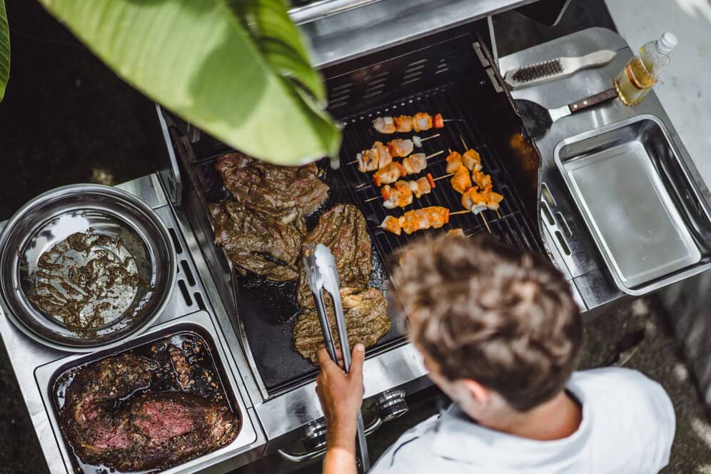 Шеф-повар готовит мясо и шашлыки на мангале во время BBQ-вечеринки EventyOn