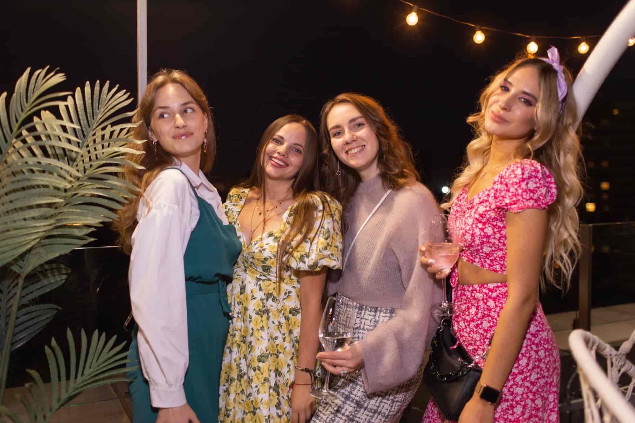 Гости с бокалами на вечерней вечеринке EventyOn на открытой площадке